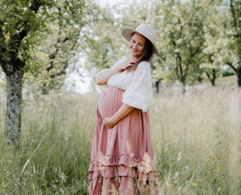 Babybauchfotos Outdoor auf Wiesen, Felder, Wälder und auf den Bergen mit schönen Vintage Schwangerschaftskleidern - Sarah Herzfoto.